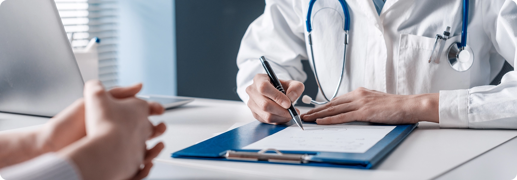 Doctor writing notes during patient consultation.